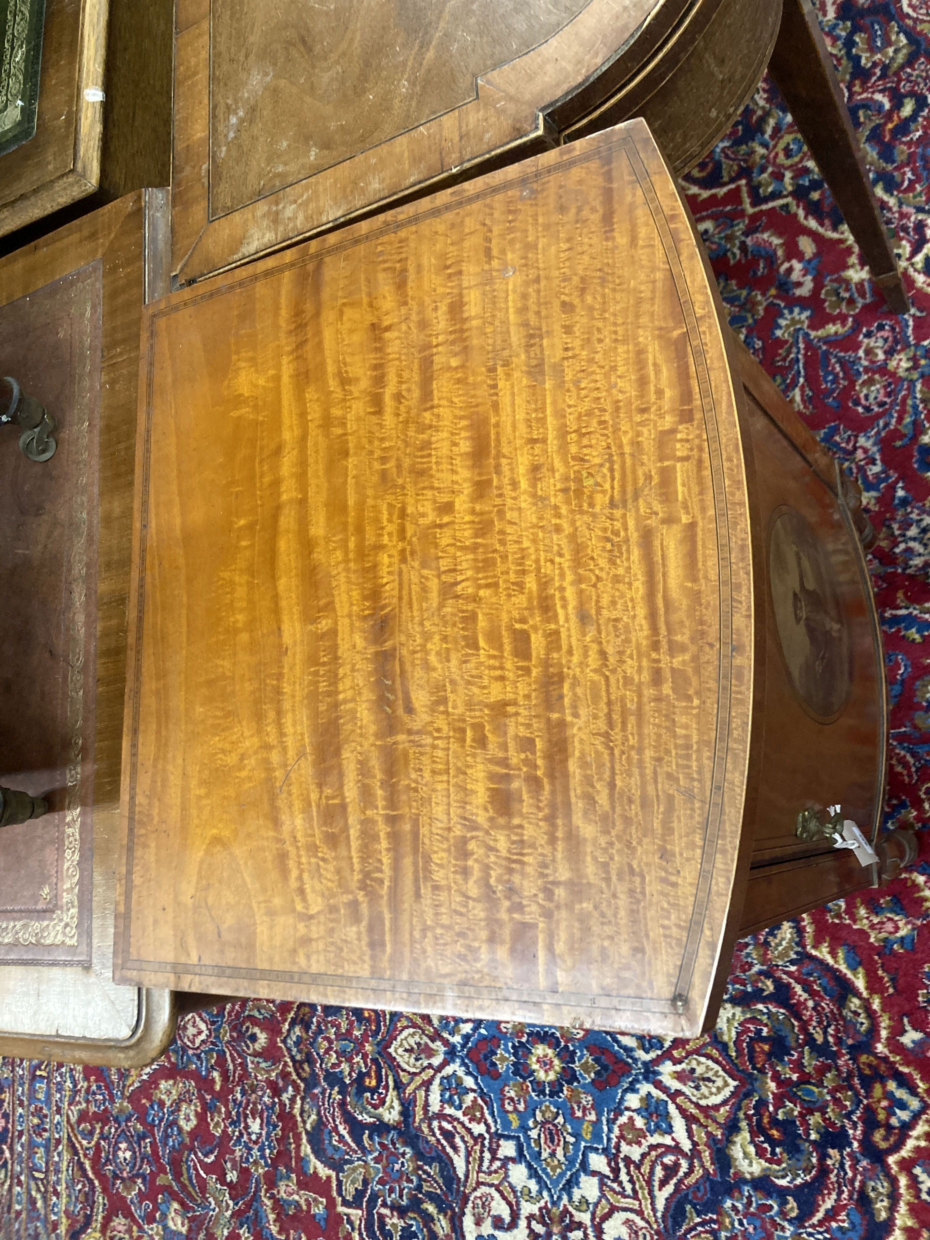 An Edwardian Sheraton revival painted satinwood bow front bedside cabinet, width 44cm, depth 39cm, height 78cm